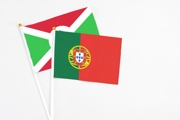 Portugal and Burundi stick flags on white background. High quality fabric, miniature national flag. Peaceful global concept.White floor for copy space.