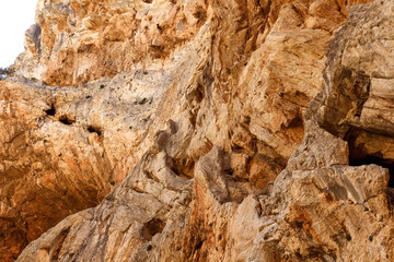 Brown red mountains shale steep cliffs near the trail, mountain trail along steep cliffs in Spain, Ardales the caminito caminito del rey. Tall red rocks mountain side in el Chorro