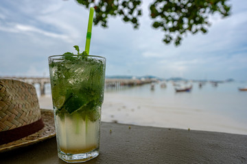 iced mojito mint soda with sea beach background 