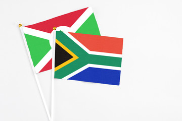 South Africa and Burundi stick flags on white background. High quality fabric, miniature national flag. Peaceful global concept.White floor for copy space.