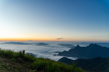 Fototapeta na wymiar Sunrise and Mist mountain in Phu Chi Fa located in Chiang Rai, Thailand. Phu Chi Fa is the natural border between Thailand and Laos.