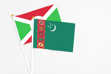 Turkmenistan and Burundi stick flags on white background. High quality fabric, miniature national flag. Peaceful global concept.White floor for copy space.