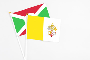 Vatican City and Burundi stick flags on white background. High quality fabric, miniature national flag. Peaceful global concept.White floor for copy space.