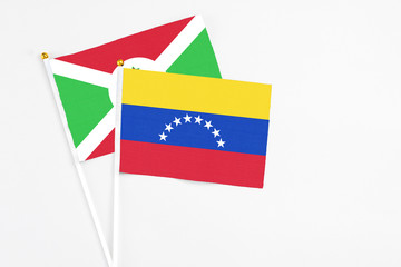 Venezuela and Burundi stick flags on white background. High quality fabric, miniature national flag. Peaceful global concept.White floor for copy space.