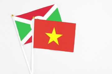 Vietnam and Burundi stick flags on white background. High quality fabric, miniature national flag. Peaceful global concept.White floor for copy space.