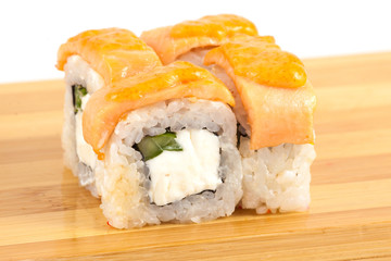 Sushi maki rolls on a wooden board.