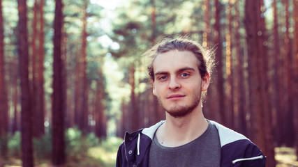 Young man with slight beard in forest