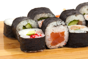 Sushi maki rolls on a wooden board.