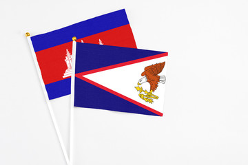 American Samoa and Cambodia stick flags on white background. High quality fabric, miniature national flag. Peaceful global concept.White floor for copy space.