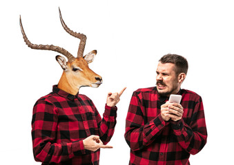 Portrait of man arguing with himself as a deer on white studio background. Concept of human...