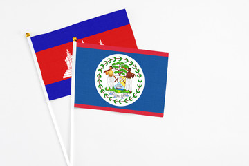 Belize and Cambodia stick flags on white background. High quality fabric, miniature national flag. Peaceful global concept.White floor for copy space.