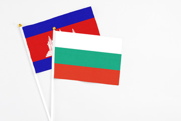 Bulgaria and Cambodia stick flags on white background. High quality fabric, miniature national...