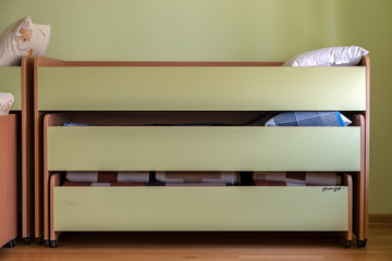 Many small beds in daycare preeschool empty bedroom.