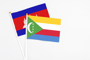 Comoros and Cambodia stick flags on white background. High quality fabric, miniature national flag....