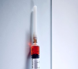 plastic syringe with red drug