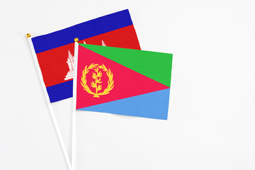 Eritrea and Cambodia stick flags on white background. High quality fabric, miniature national flag. Peaceful global concept.White floor for copy space.