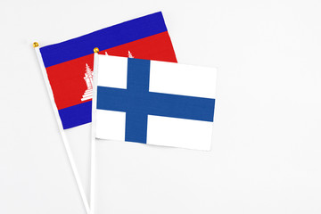 Finland and Cambodia stick flags on white background. High quality fabric, miniature national flag. Peaceful global concept.White floor for copy space.