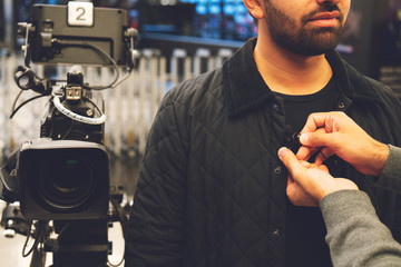 Television video camera recording interview in broadcast news studio. Blurred background. Media,...