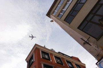 Passenger plane flying over the roofs of residential homes, low airplane flies, transportation
