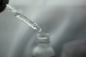 Naklejka na ściany i meble Closeup of a piepette with clear serum on a white background. 