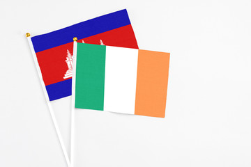 Ireland and Cambodia stick flags on white background. High quality fabric, miniature national flag. Peaceful global concept.White floor for copy space.