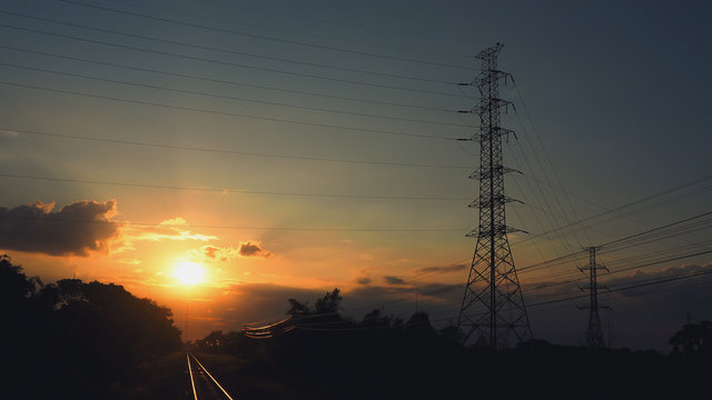 Pictures of electrical transportation through high voltage poles during sunrise time. Electric power transportation concept