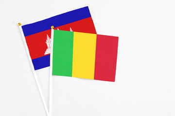 Mali and Cambodia stick flags on white background. High quality fabric, miniature national flag. Peaceful global concept.White floor for copy space.