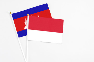 Monaco and Cambodia stick flags on white background. High quality fabric, miniature national flag....