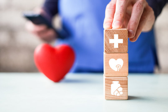 Doctor hand arranging wood block stacking with healthcare icons, insurance for your health.