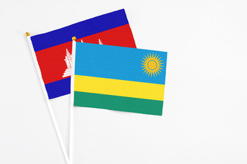 Rwanda and Cambodia stick flags on white background. High quality fabric, miniature national flag....