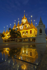 Beautiful Loha Prasat or iron monastery of Wat Ratchanatdaram in blue hour with reflection , Bangkok, Thailand