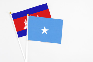 Somalia and Cambodia stick flags on white background. High quality fabric, miniature national flag. Peaceful global concept.White floor for copy space.