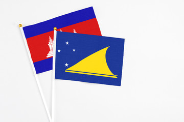 Tokelau and Cambodia stick flags on white background. High quality fabric, miniature national flag. Peaceful global concept.White floor for copy space.
