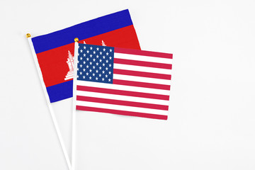 United States and Cambodia stick flags on white background. High quality fabric, miniature national flag. Peaceful global concept.White floor for copy space.