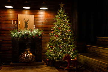 Christmas and New Year interior - blur background: fireplace, lamps, green Christmas tree, brown...