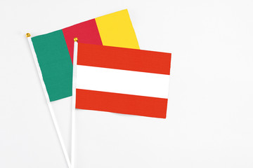 Austria and Cameroon stick flags on white background. High quality fabric, miniature national flag. Peaceful global concept.White floor for copy space.