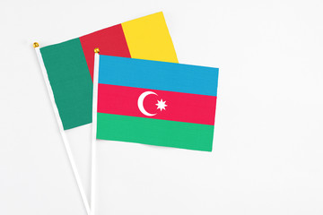 Azerbaijan and Cameroon stick flags on white background. High quality fabric, miniature national flag. Peaceful global concept.White floor for copy space.