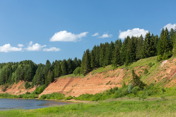 Beautiful summer landscape with green meadows, blue sky, sun and a river