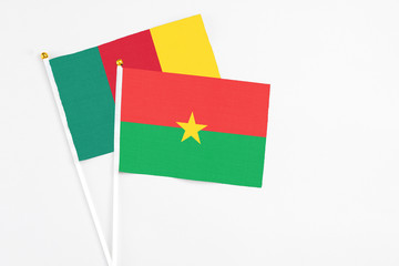 Burkina Faso and Cameroon stick flags on white background. High quality fabric, miniature national flag. Peaceful global concept.White floor for copy space.