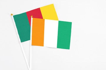 Cote D'Ivoire and Cameroon stick flags on white background. High quality fabric, miniature national...