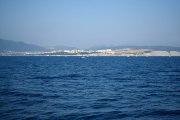 The view from the sea to the coast and mountains in the background on a sunny day