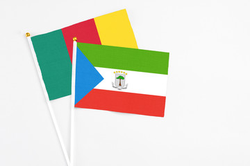 Equatorial Guinea and Cameroon stick flags on white background. High quality fabric, miniature national flag. Peaceful global concept.White floor for copy space.