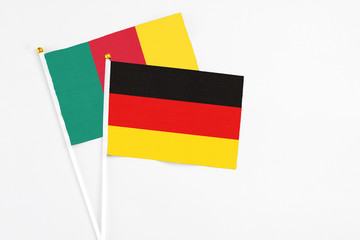 Germany and Cameroon stick flags on white background. High quality fabric, miniature national flag. Peaceful global concept.White floor for copy space.