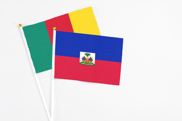 Haiti and Cameroon stick flags on white background. High quality fabric, miniature national flag. Peaceful global concept.White floor for copy space.