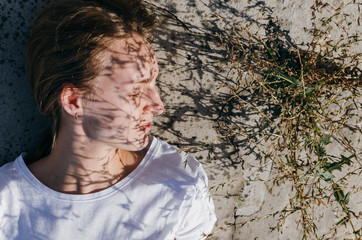Headshot portrait of female looking away with floral shadow on her face