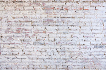 old white brick wall with crumbling plaster