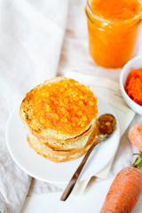 Vegetarian organic sweet carrot jam or marmalade toast topping for breakfast top view.Healthy vegetable dessert on white background.Vertical orientation