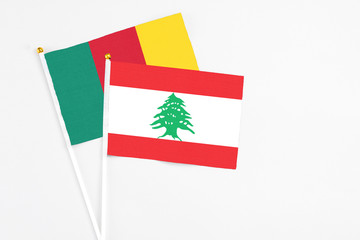Lebanon and Cameroon stick flags on white background. High quality fabric, miniature national flag. Peaceful global concept.White floor for copy space.