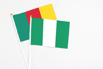 Nigeria and Cameroon stick flags on white background. High quality fabric, miniature national flag. Peaceful global concept.White floor for copy space.