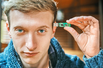 man holds a flash drive near his head. modern technology memory concept